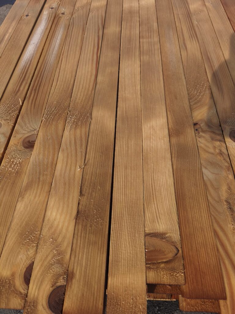 Dřevěná podlaha s tlakovou impregnací, odolná vůči povětrnostním vlivům a dlouhodobé životnosti. Ideální pro venkovní použití.