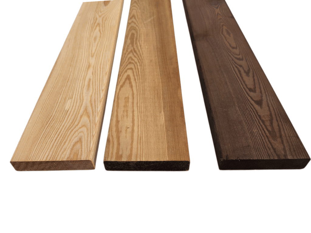 Tři terasová prkna z evropského modřínu s tlakovou impregnací v přírodních odstínech, vhodná pro venkovní terasy.