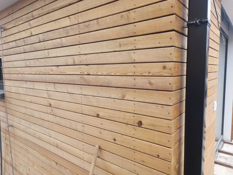 Tlakově impregnované dřevo s tlakovou impregnací na exteriérové fasádě.